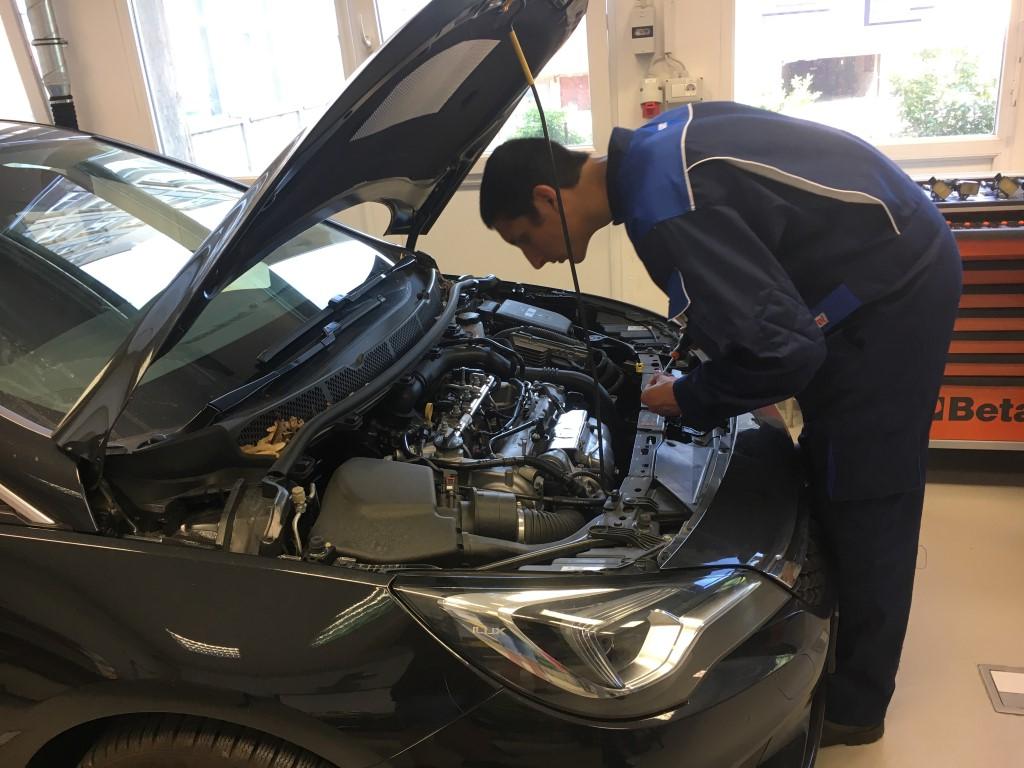 Tekmovalec pri pregledu motorja avtomobila.