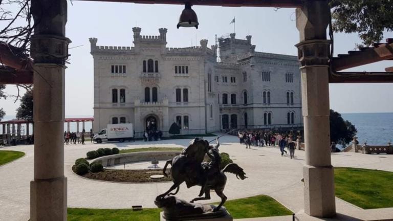Grad Miramare s parkom in pogledom na morje.