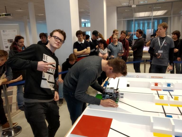 Dijaki pri preizkušanju robota na tekmovalni mizi LEGO.