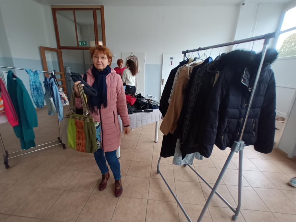Udeleženka si ogleduje oblačila na izmenjevalnici.