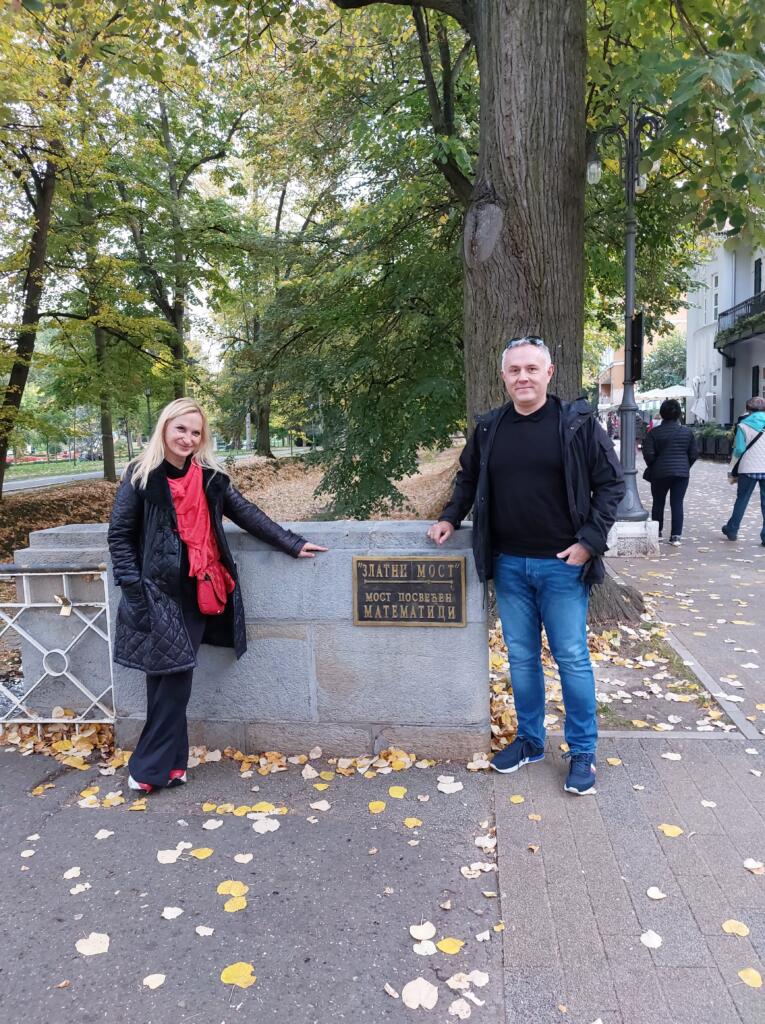 Udeleženca ob spomeniku v parku.