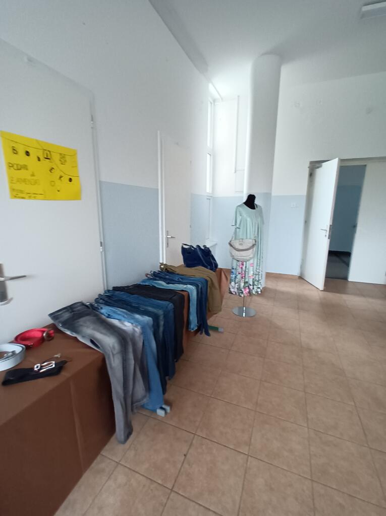 Kavbojke, razporejene na mizi v izmenjevalnici oblačil.