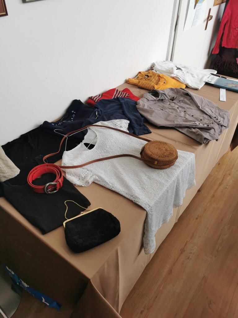 Torbice, pasovi in oblačila na mizi za izmenjavo.