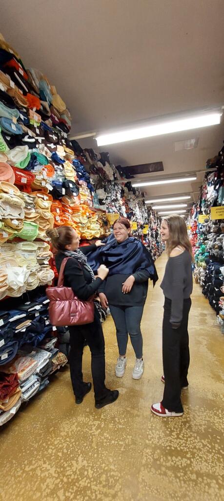 Obiskovalke med policami s pisanimi tekstilnimi materiali.