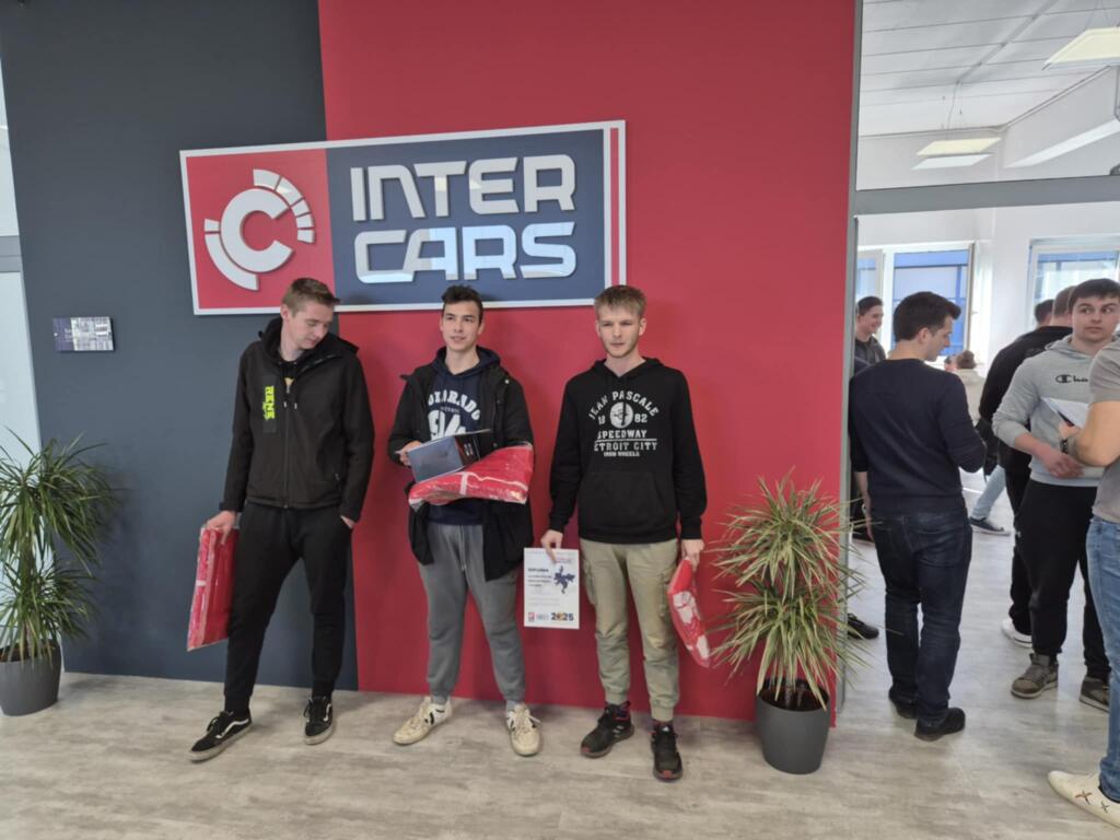 Tekmovalci s priznanji pred oznako Inter Cars.